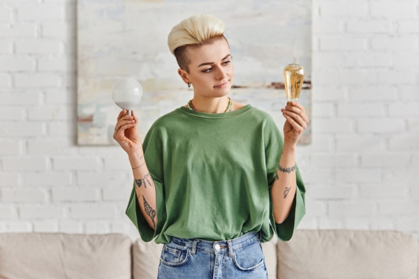 Woman holding different light bulbs deciding which is more energy efficient
