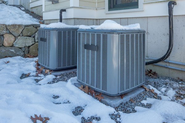 ac unit covered with snow in winter without an air conditioner cover