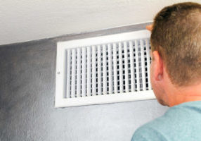 Man Looking in an HVAC Air Vent