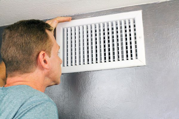 image of a man looking at hvac air registers