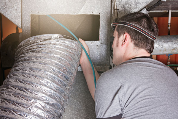 image of technician inspecting hvac ductwork
