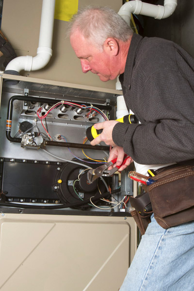 image of a furnace technician tuning up furnace hvac system