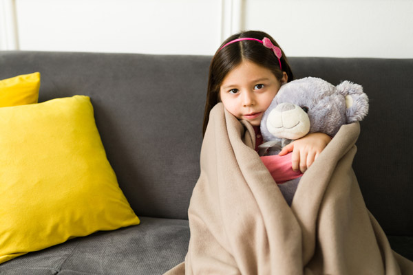 image of a girl feeling chilly due to furnace not turning on with thermostat