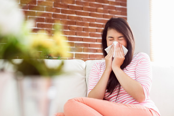 image of a homeowner blowing thier nose due to poor indoor air quality