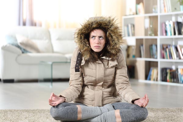 image of a homeowner feeling chilly due leaky windows in house during winter