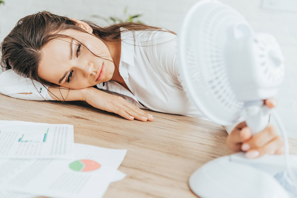 image of a homeowner feeling hot and uncomfortable due to summer heat and air conditioner