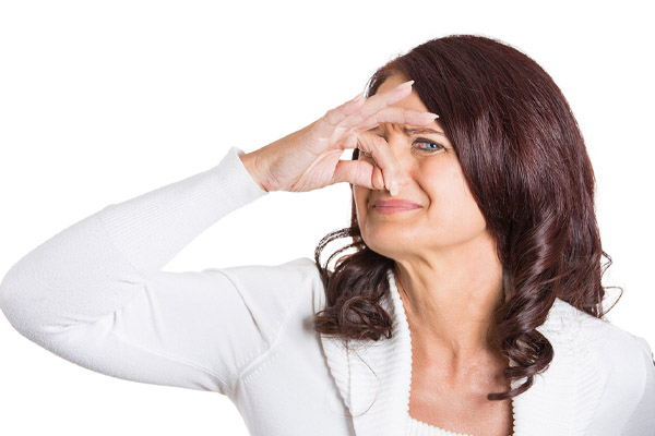 image of a homeowner plugging nose due to indoor air pollutants at home