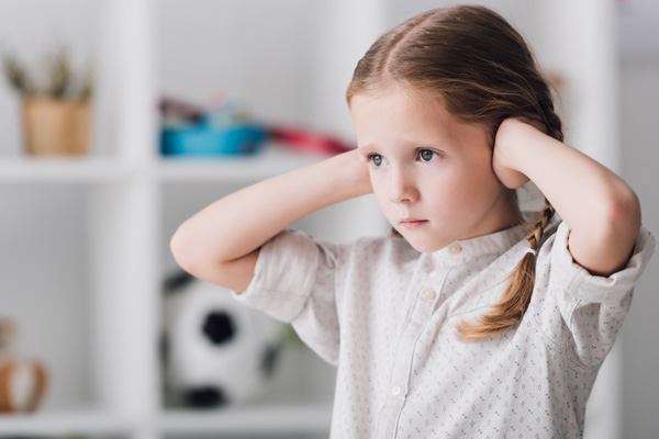 image of a kid covering ears due to loud window ac unit