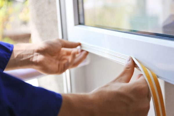 image of a man sealing a window