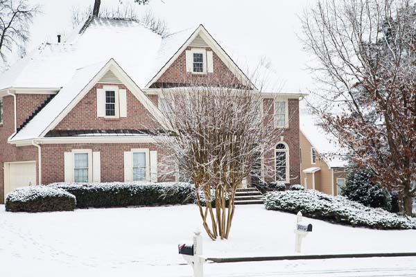 image of a snow-covered house in new jersey that uses heat pump and auxiliary heat