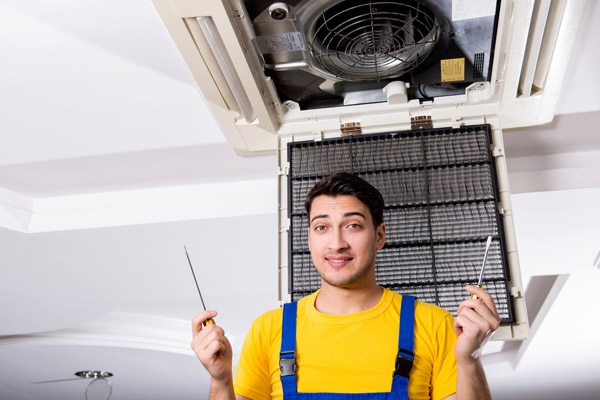 image of an HVAC contractor repairing an air conditioner