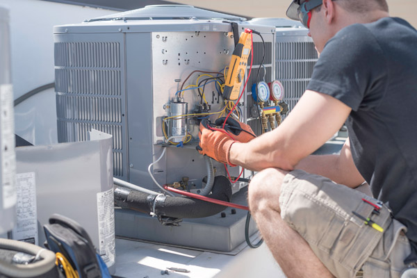 image of an HVAC technician working on air conditioning system