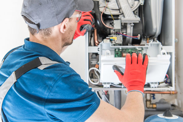 image of an hvac contractor performing furnace maintenance