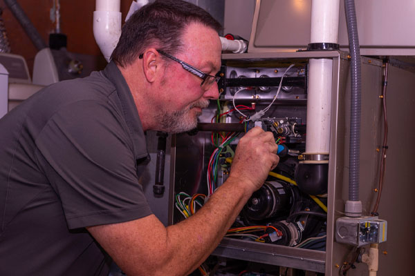 image of an hvac technician performing a heating system tune-up