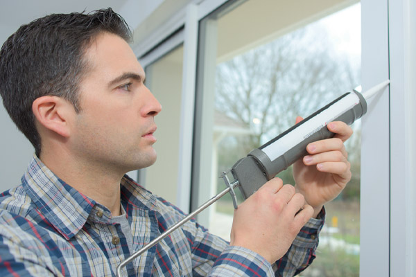 image of homeowner sealing air drafts