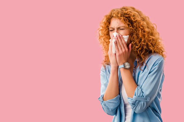 image of homeowner sneezing due to poor indoor air quality depicting uv lights for hvac system