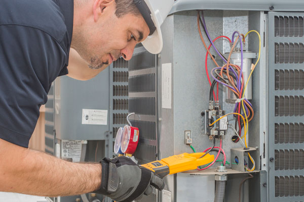 image of hvac contractor repairing air conditioner electrical issues