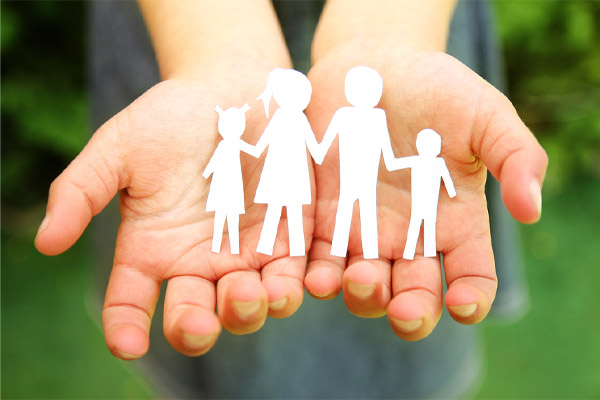 image of paper cut out of family in hands depicting home comfort