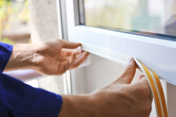 image of person sealing air drafts