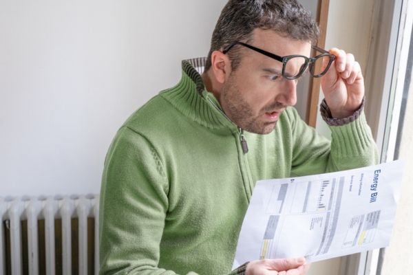 shocked man looking at increased energy bills