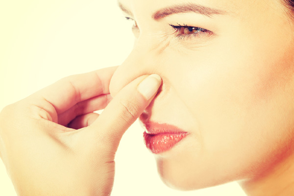 woman plugging nose due to smelly air conditioner