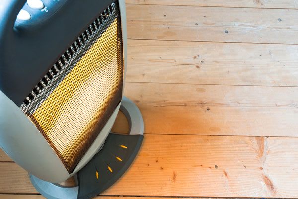 woman using space heater incorrectly