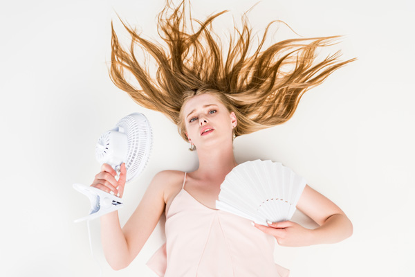 woman who is suffering from heat due to a broken air conditioner